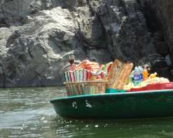 Local vendors sell freshly caught fish, water, and snacks on their Mobile shops on coracle at the falls.